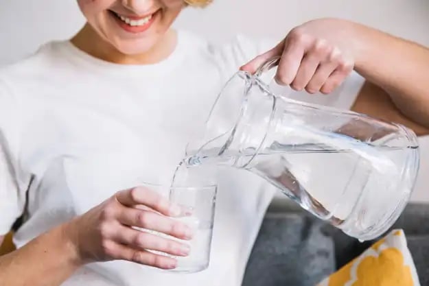 crop-woman-filling-glass-with-water.